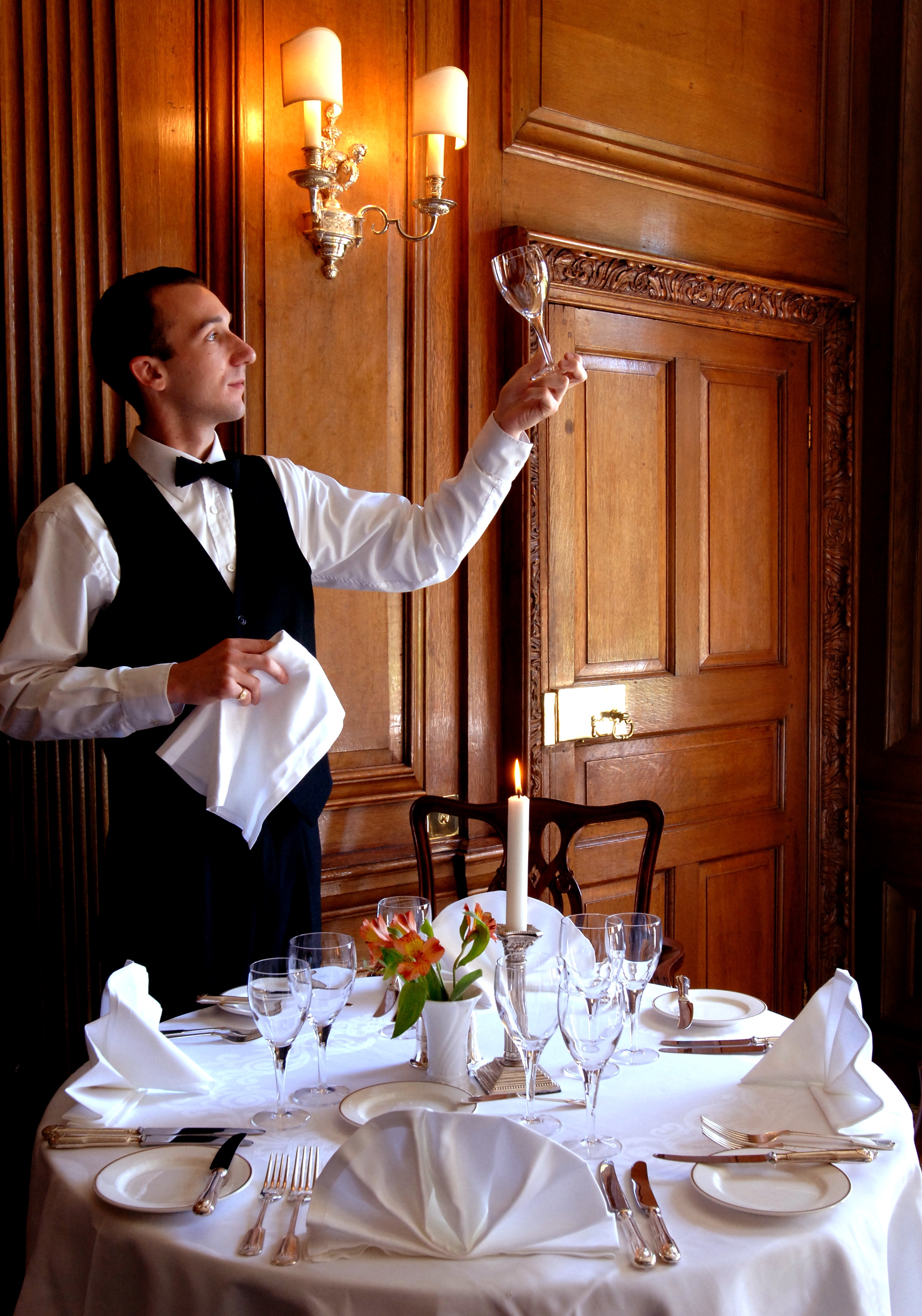 Waiter setting table in Oak Dining Room at Middlethorpe Hall