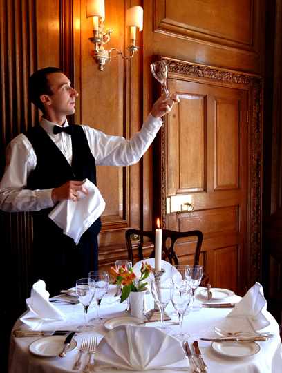 Waiter setting table in Oak Dining Room at Middlethorpe Hall