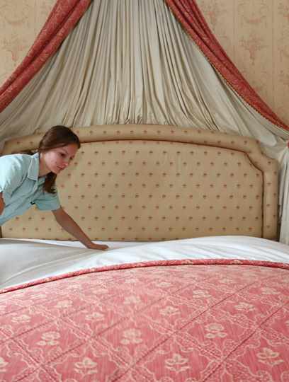 Chamber maid making bed in Duke of York Suite at Middlethorpe Hall