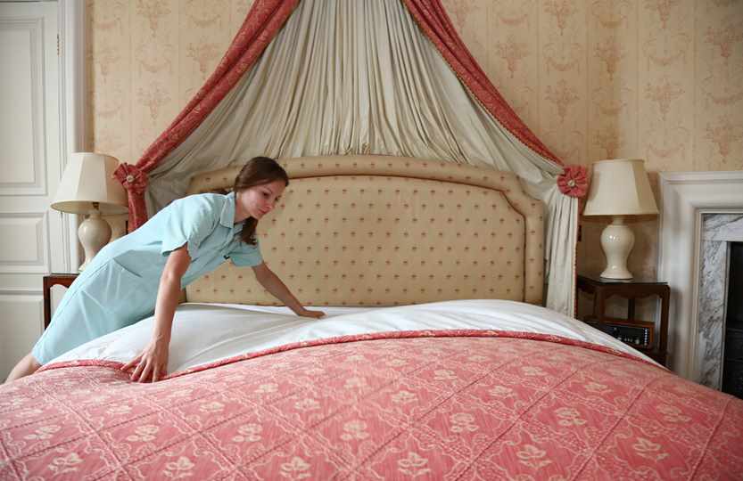 Chamber maid making bed in Duke of York Suite at Middlethorpe Hall